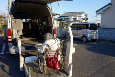 senior woman in a wheelchair getting into a vehicle with a lift