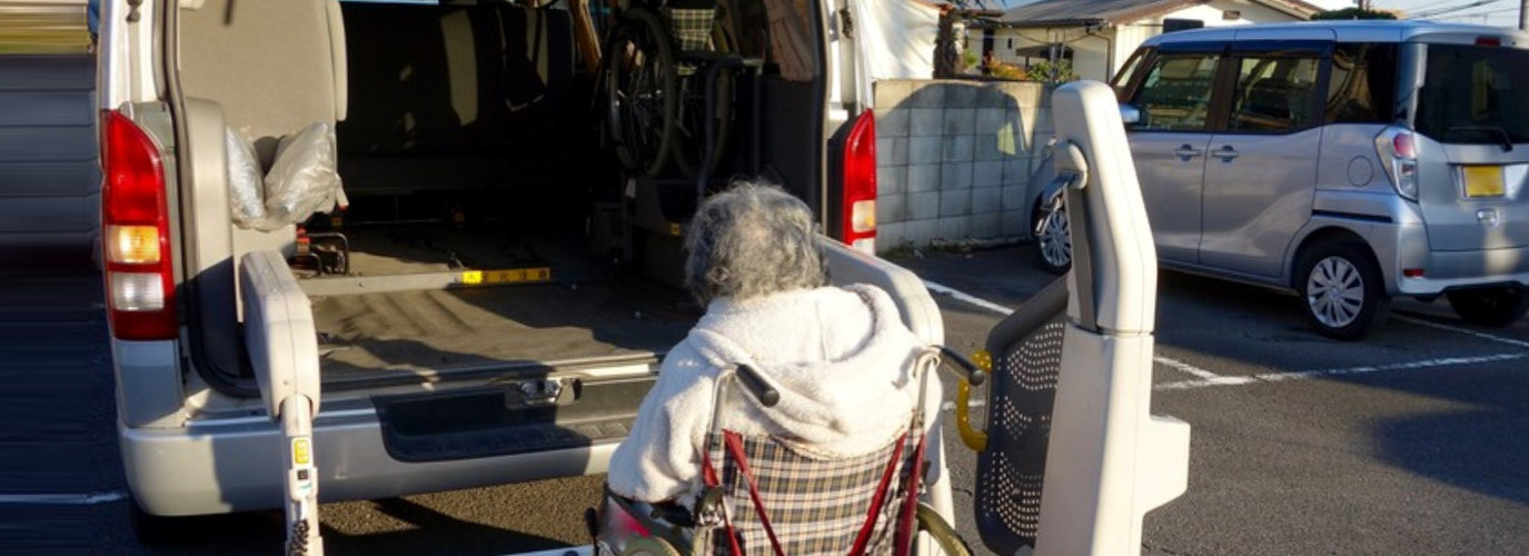senior woman in a wheelchair getting into a vehicle with a lift